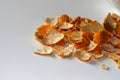 Defocus peels of orange and tangerine on a white background. Many small pieces of dried peel of mandarin. Orange bright Royalty Free Stock Photo