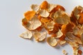 Defocus peels of orange and tangerine on a white background. Many small pieces of dried peel of mandarin. Orange bright Royalty Free Stock Photo