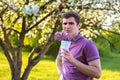 Defocus portrait of handsome caucasian man with cone flowers in lilac garden Thinking young brunette guy smelling fresh