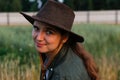 Defocus portrait smiling young woman in cowboy hat. Girl in a cowboy hat in a field. Nature background. Closeup portrait Royalty Free Stock Photo