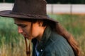 Defocus portrait smiling young woman in cowboy hat. Girl in a cowboy hat in a field. Nature background. Closeup portrait Royalty Free Stock Photo