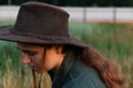 Defocus portrait smiling young woman in cowboy hat. Girl in a cowboy hat in a field. Nature background. Closeup Royalty Free Stock Photo