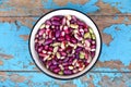 Defocus purple beans background. Plate on blue background of many grains of dried beans. Brown beans texture. Food Royalty Free Stock Photo