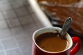 Defocus red cup of coffee with spoon. Hot coffee with smoke on old wooden table at coffee shop in the morning. Out of Royalty Free Stock Photo