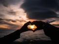 Defocus of Silhouette Heart Hand sign with Sunrise