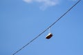 Defocus sneakers hanging from electrical wire against a blue sky background. The concept of urban culture, sale of Royalty Free Stock Photo