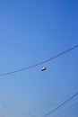 Defocus sneakers hanging from electrical wire against a blue sky background. The concept of urban culture, sale of Royalty Free Stock Photo
