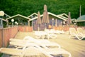 Defocus summer landscape recreation deck chairs pool umbrella wooden house fence. Royalty Free Stock Photo