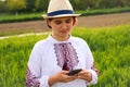 Defocus young ukrainian woman portrait. Meadow nature background. Sad ukrainian girl scrolling phone. Mental health