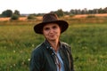 Defocus young woman in cowboy hat. Girl in a cowboy hat in a field. Sunset. Nature background. Closeup portrait Royalty Free Stock Photo