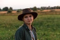 Defocus young woman in cowboy hat. Girl in a cowboy hat in a field. Sunset. Nature background. Closeup portrait Royalty Free Stock Photo