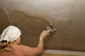 Defocus young woman doing home repairs by applying plaster using a trowel. Woman painting wall in her new apartment Royalty Free Stock Photo