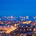defocused abstract city lights in the twilight with river, reflection and horizon, bokeh background, closeup