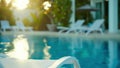 Through the defocused background glimpses of a serene pool and comfortable loungers can be seen. The inviting blue
