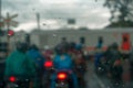 Defocused background of people on motorcycle waiting for the train to pass.