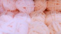 Defocused background of soft balls of wool in pink colors. The concept of coziness and comfort.