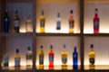 Defocused background of various alcohol bottles in a bar or restaurant. Bar advertisement mockup image Royalty Free Stock Photo