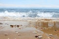 Defocused beach with blurred wave and wet sand with pebble on blue sky. Sea, ocean background. Vacation outdoor and travel holiday Royalty Free Stock Photo