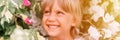 Defocused blurred portrait of face candid little happy smiling five year old blonde kid boy with green eyes in pink and white flow