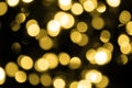 Defocused bokeh christmas gold lights on black background. Royalty Free Stock Photo