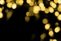 Defocused bokeh christmas gold lights on black background. Royalty Free Stock Photo