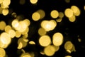 Defocused bokeh christmas gold lights on black background.