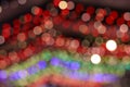 Defocused bokeh of colorful Christmas lights background at the festive street fair. Royalty Free Stock Photo