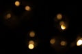 Defocused bokeh lights of a garland on black background, an abstract naturally blurred backdrop Royalty Free Stock Photo