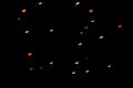 Defocused bokeh multicolor lights in shape of bats on black background. Halloween background.