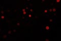 Defocused bokeh red small lights on black background. Blurred abstract red glitter wallpaper Royalty Free Stock Photo