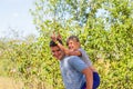 Defocused brother giving sister ride on back. Portrait of happy girl with funny horns on man shoulders, piggyback Royalty Free Stock Photo