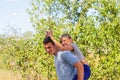 Defocused brother giving sister ride on back. Portrait of happy girl with funny horns on man shoulders, piggyback Royalty Free Stock Photo