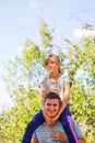 Defocused brother giving sister ride on back. Portrait of happy girl on man shoulders, piggyback. Family playing outdoor Royalty Free Stock Photo