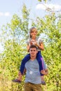 Defocused brother giving sister ride on back. Portrait of happy girl on man shoulders, piggyback. Family playing outdoor Royalty Free Stock Photo