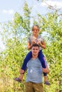 Defocused brother giving sister ride on back. Portrait of happy girl on man shoulders, piggyback. Family playing outside Royalty Free Stock Photo