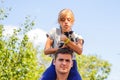 Defocused brother giving sister ride on back. Portrait of happy girl on man shoulders, piggyback. Girl holding cat, kitten. Family Royalty Free Stock Photo