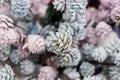 Defocused Christmas background filled of pastel colors painted pinecones for xmas tree decoration.