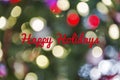 Defocused Christmas light background with Happy Holidays text