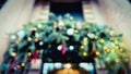 Defocused Christmas ornaments upon entrance. Xmas wreathe with golden bokeh lights. Fir tree decoration in winter. Soft