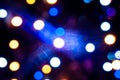 Defocused colorful christmas lights with sparkle and reflections on dark background with bokeh effect Royalty Free Stock Photo