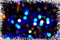 Defocused colorful ligths of Christmas tree. Multicolored bokeh lights during a snowfall. Background for greeting card Royalty Free Stock Photo