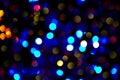 Defocused colorful ligths of Christmas tree. Multicolored bokeh lights during a snowfall. Background for greeting card. Winter Royalty Free Stock Photo