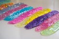 Defocused colorful slimes inside plastic boxes. Set of kids gunk toy, close up view. How to make fluffy slime at home