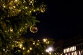 Defocused golden Christmas balls and blurry shiny lights of outdoor Christmas tree on dark background of street in Berlin Germany. Royalty Free Stock Photo
