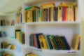 Defocused image, bokeh effect. Books on the shelves in the library