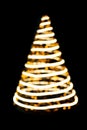 Defocused lights spiral Christmas tree on black isolated background. Design element. New Year