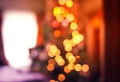 Defocused ligths of decorated Christmas tree in the rural house interior. Blurred New year festive background.