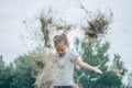 Defocused little girl 3-4 years old jumps and plays in hay stack, throwing it up. Motion blur Royalty Free Stock Photo