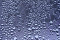 Defocused macro abstract art texture of window condensation with blue hued water drops Royalty Free Stock Photo