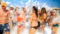 Defocused image of big group of people dancing on the sea beach disco party. People having fun during summer holiday Royalty Free Stock Photo